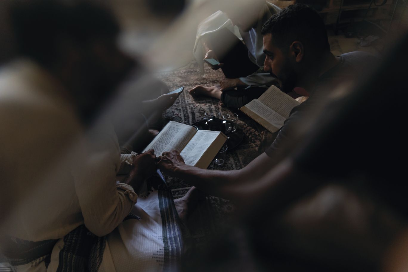 Hombres en el suelo leyendo la Biblia.